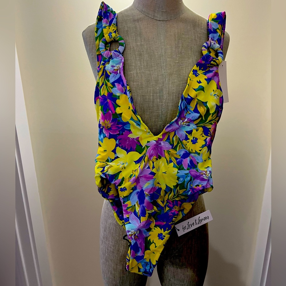 One piece bathing suit, daffodil print, has a high rise. Two straps in back